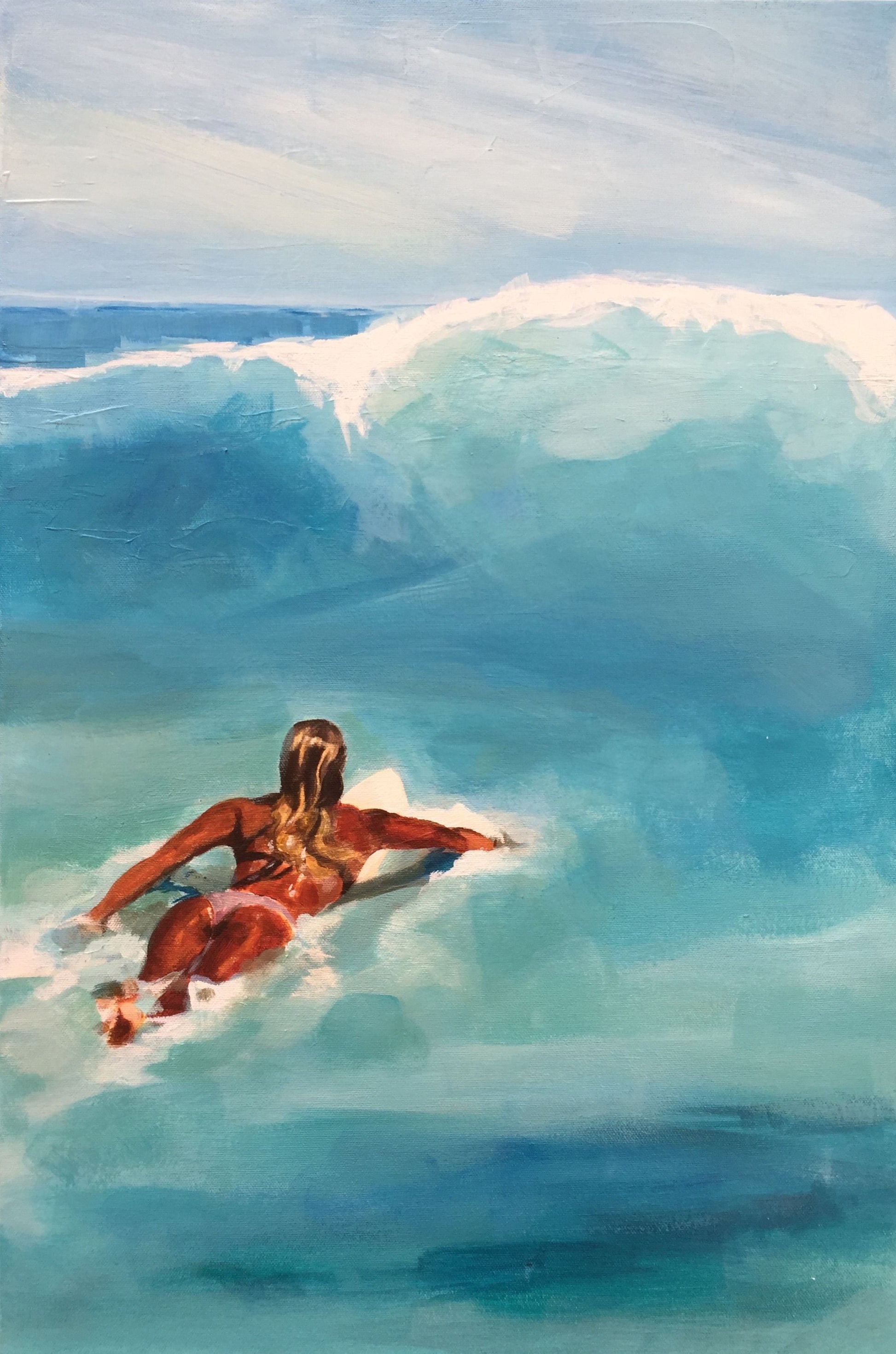 Beautiful surfer girl paddling out on a surfboard