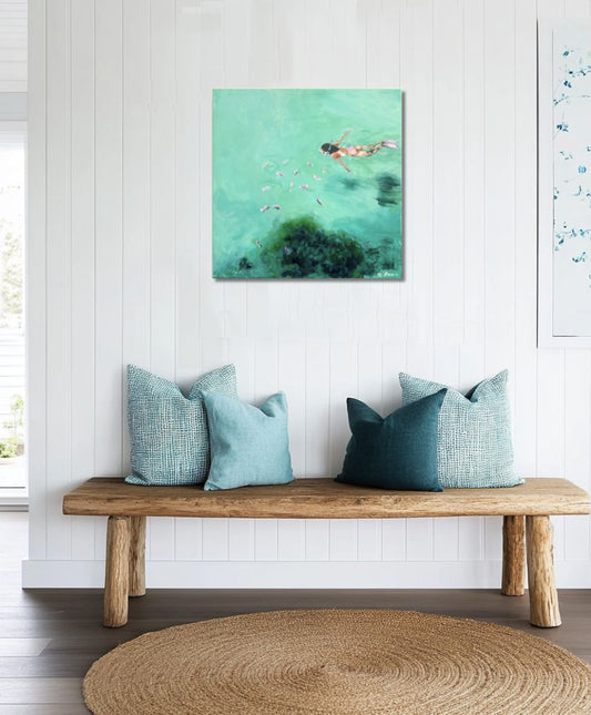 Wooden bench with decorative pillows against a white wall with a colorful abstract painting.
